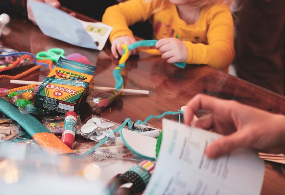 A child at a table covered in craft supplies